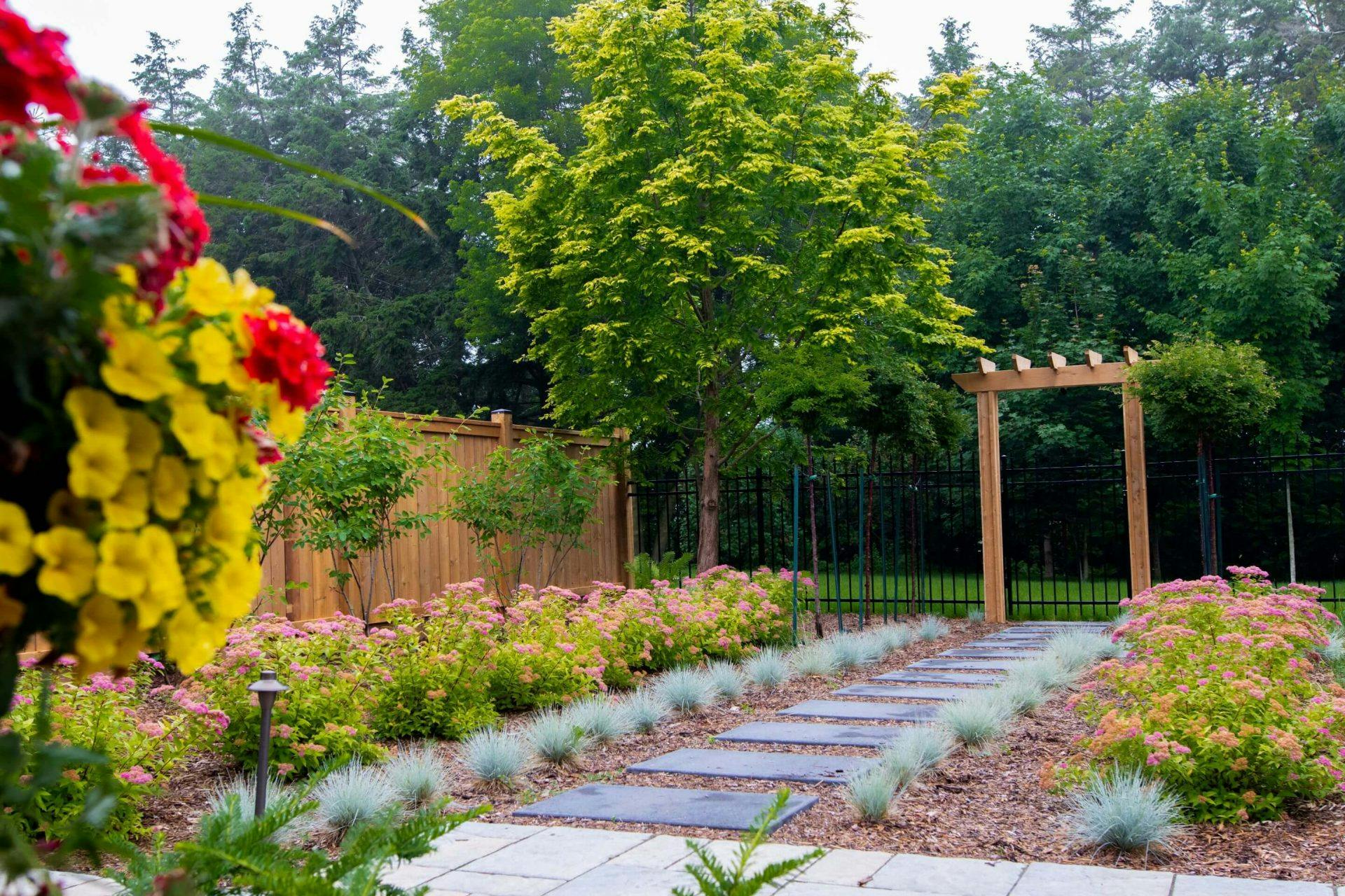Stone walkway through a garden to a back gate