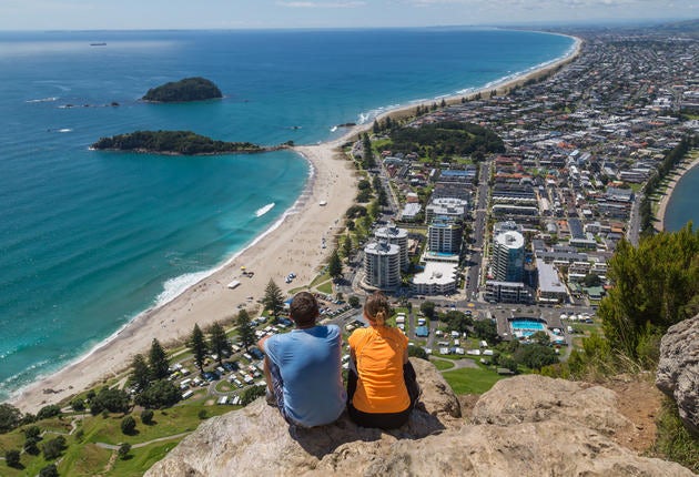 Two people sitting on the top of a mountain