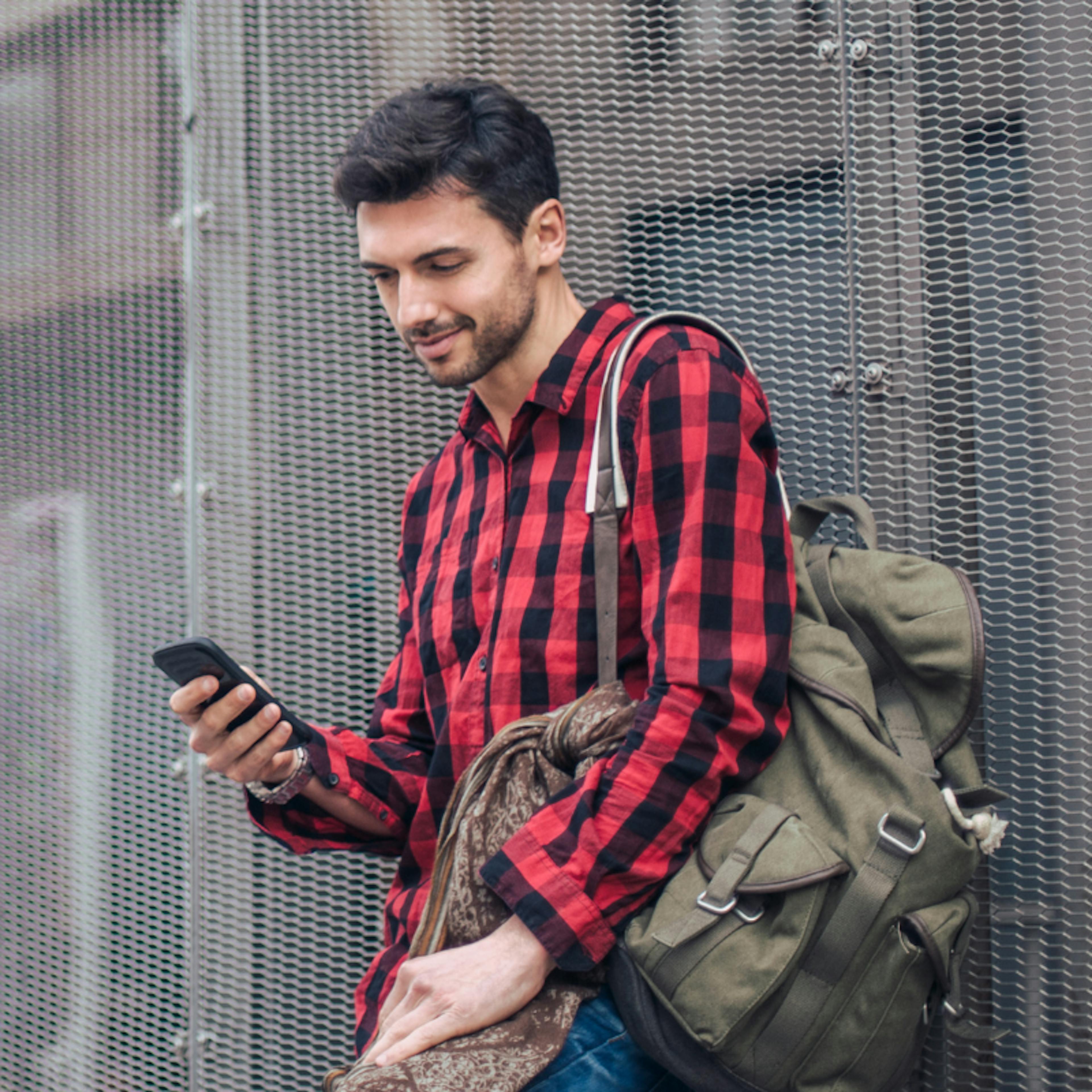 Young man in checked shirt looking at phone
