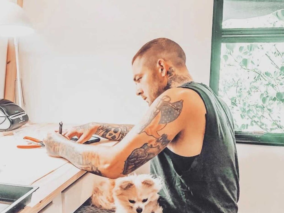 Man at desk with dog on his lap. 