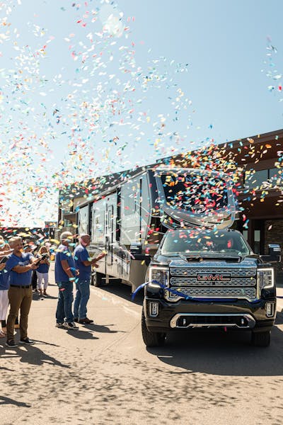 Keystone empolyees throwing confetti as the one millionth RV produced drives away. 