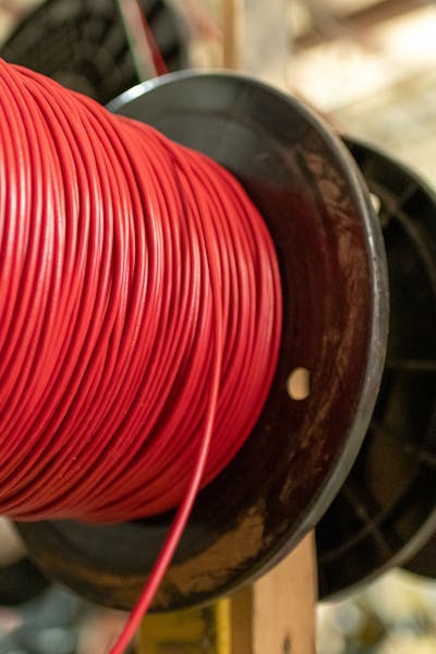 Close-up of red and purple spools of industrial electrical wire.