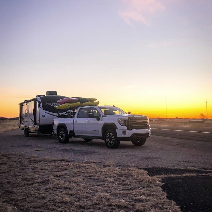 Outback with GMC truck, loaded with Kayaks at the beach at sunset