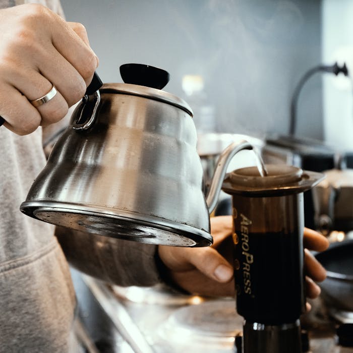 Someone pouring boiling water into aeropress coffee maker.