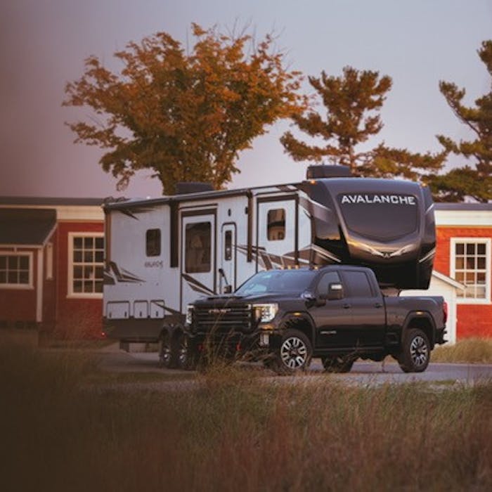 Keystone Avalanche fifth wheel RV being pulled by a GMC Sierra HD Denali.