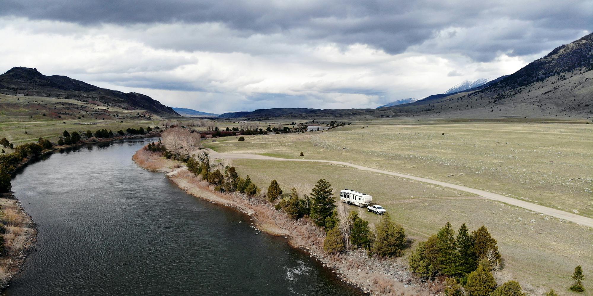 A fifth wheel parked alongside a river near Yellowstone National Park