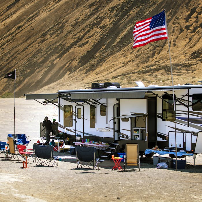 Keystone Fuzion in desert with mountains in the background and dirt bikers in the foreground