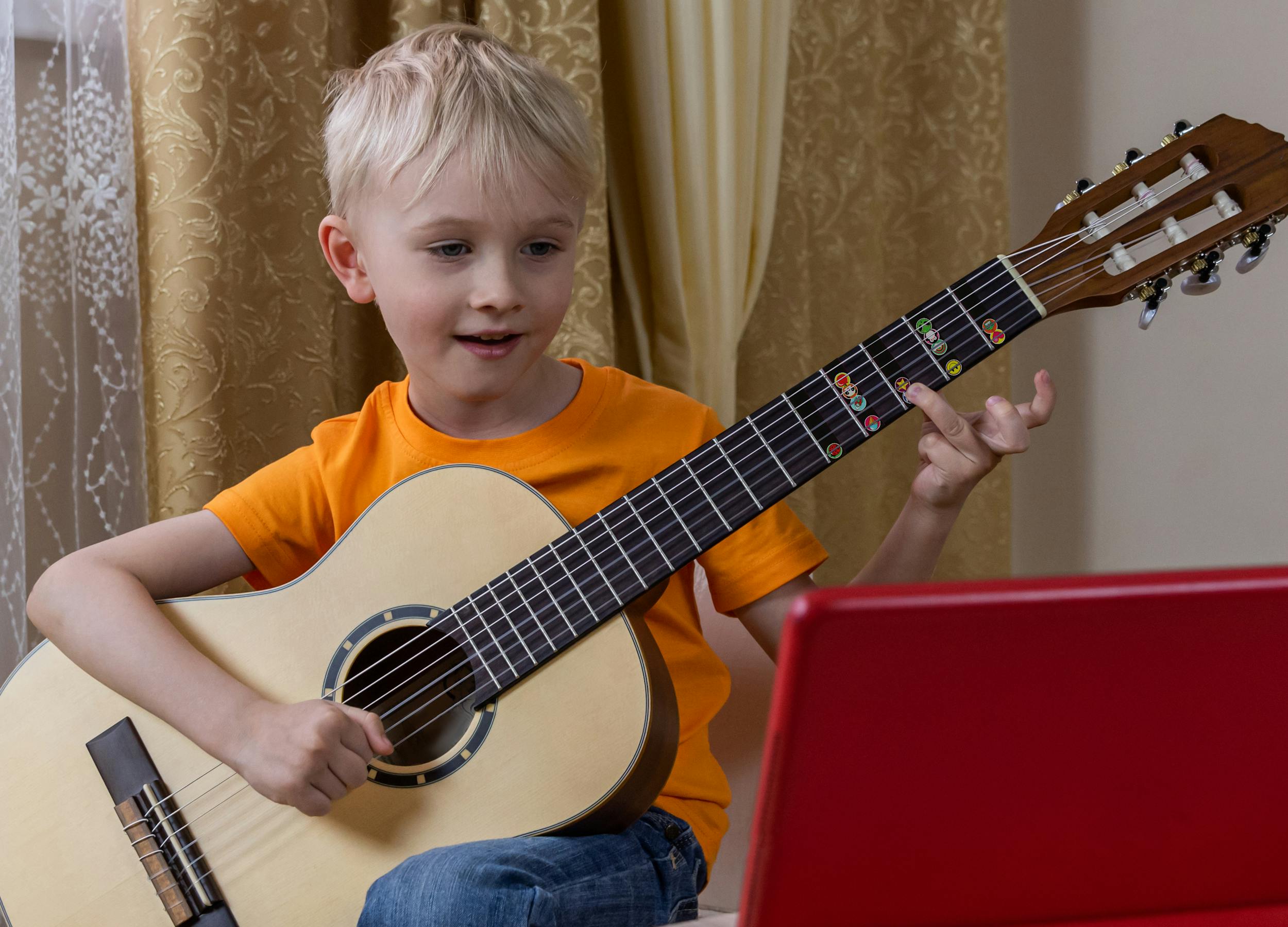 child-learning-guitar-with-correctly-sized instrument