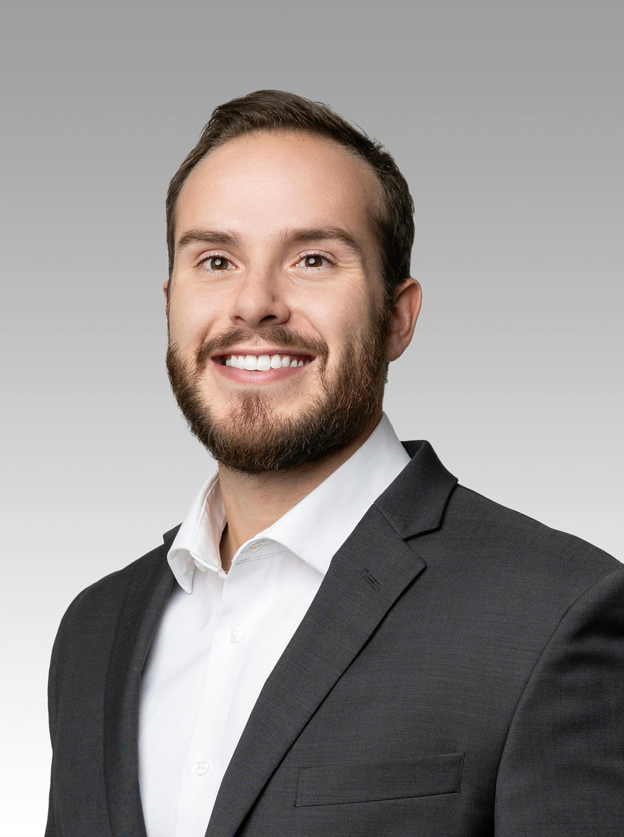 Josh Carter headshot on a gray gradient backdrop