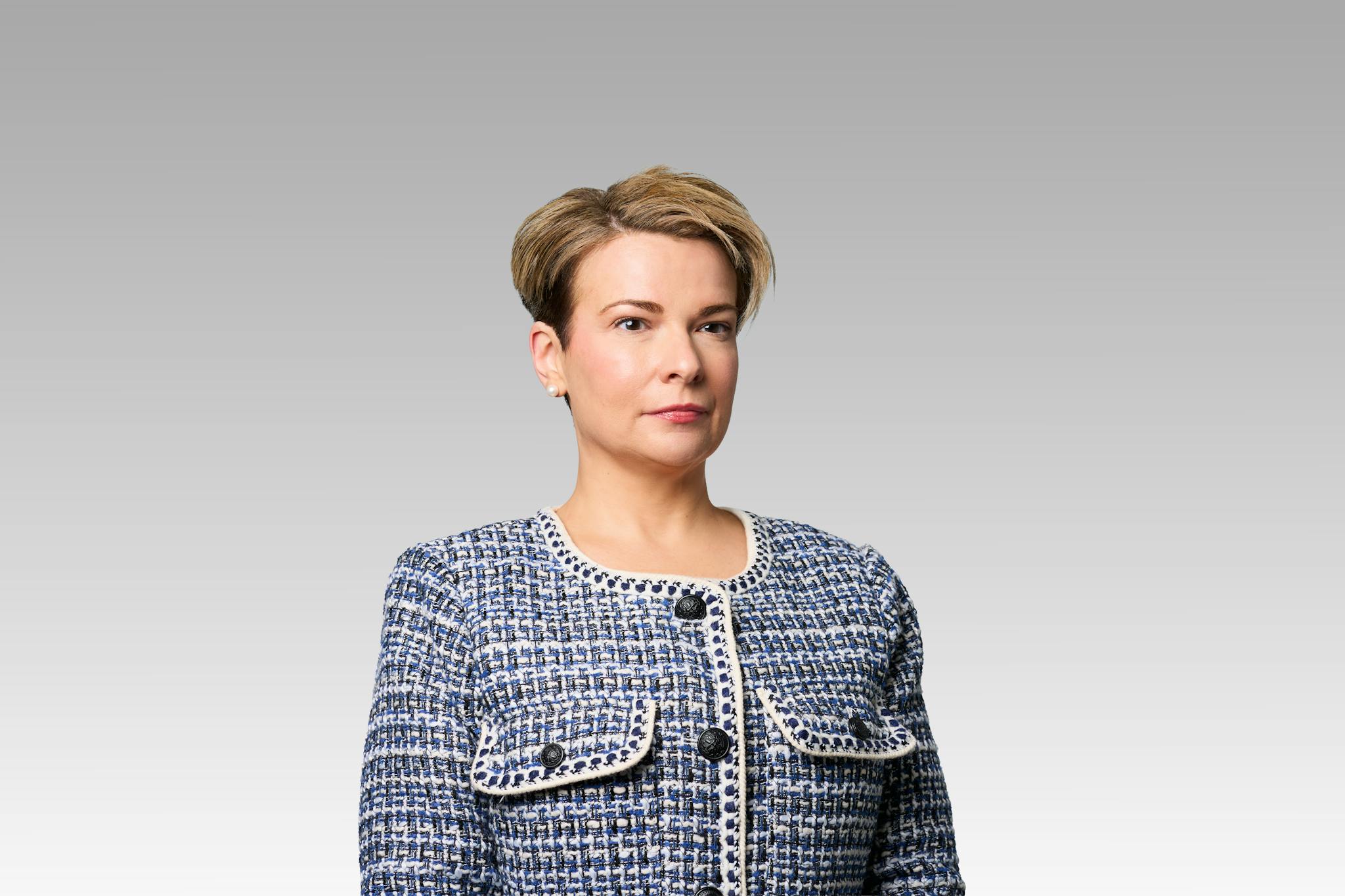 Danelle Cini headshot on a gray gradient backdrop