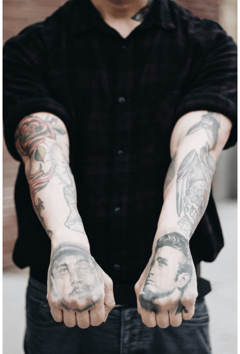 A man with Portrait Style Tattoos on his arms