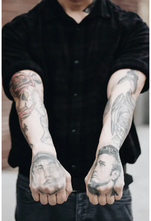 A man with Portrait Style Tattoos on his arms