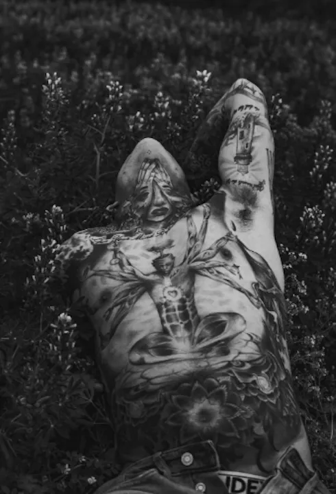 A man with a surreal style tattoo on his torso