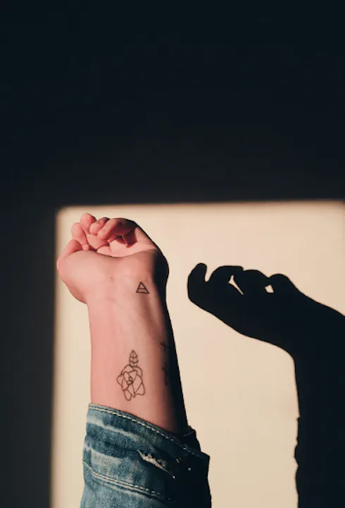 An arm with a stick and poke tattoo