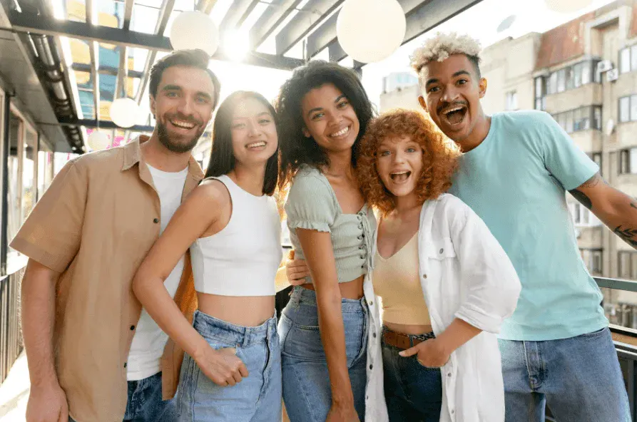 Família sorridente em ambiente externo, com cinco pessoas com roupas casuais e tom alegre, mostrando união e descontração em um passeio de rua
