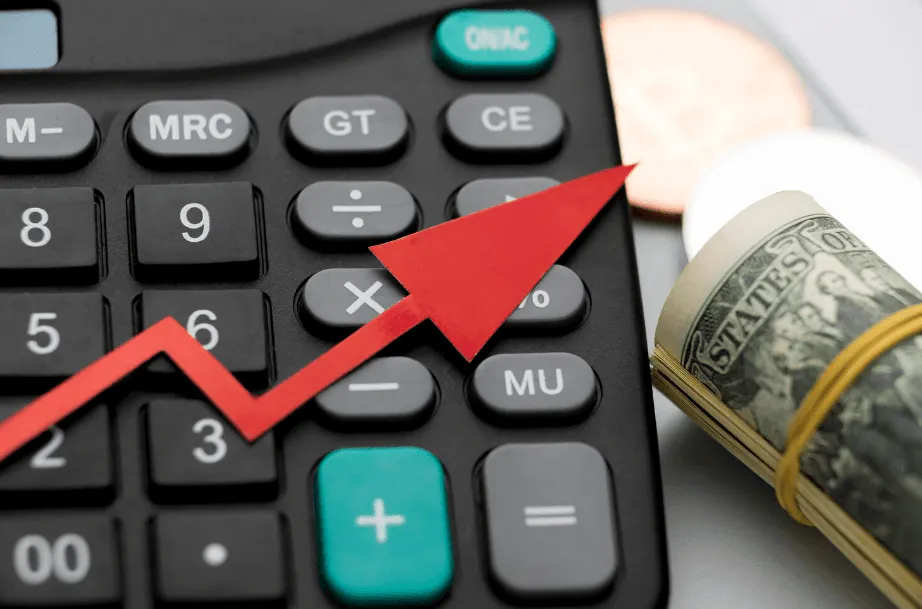 Calculadora com setas de crescimento em vermelho e dinheiro ao lado, indicando aumento de ganhos e planejamento financeiro com foco em resultados.