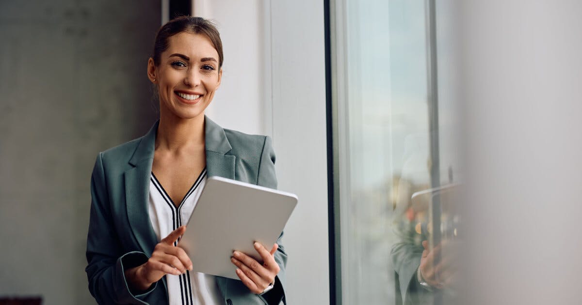 Uma mulher em um terno de negócios segurando um tablet, demonstrando profissionalismo e tecnologia.