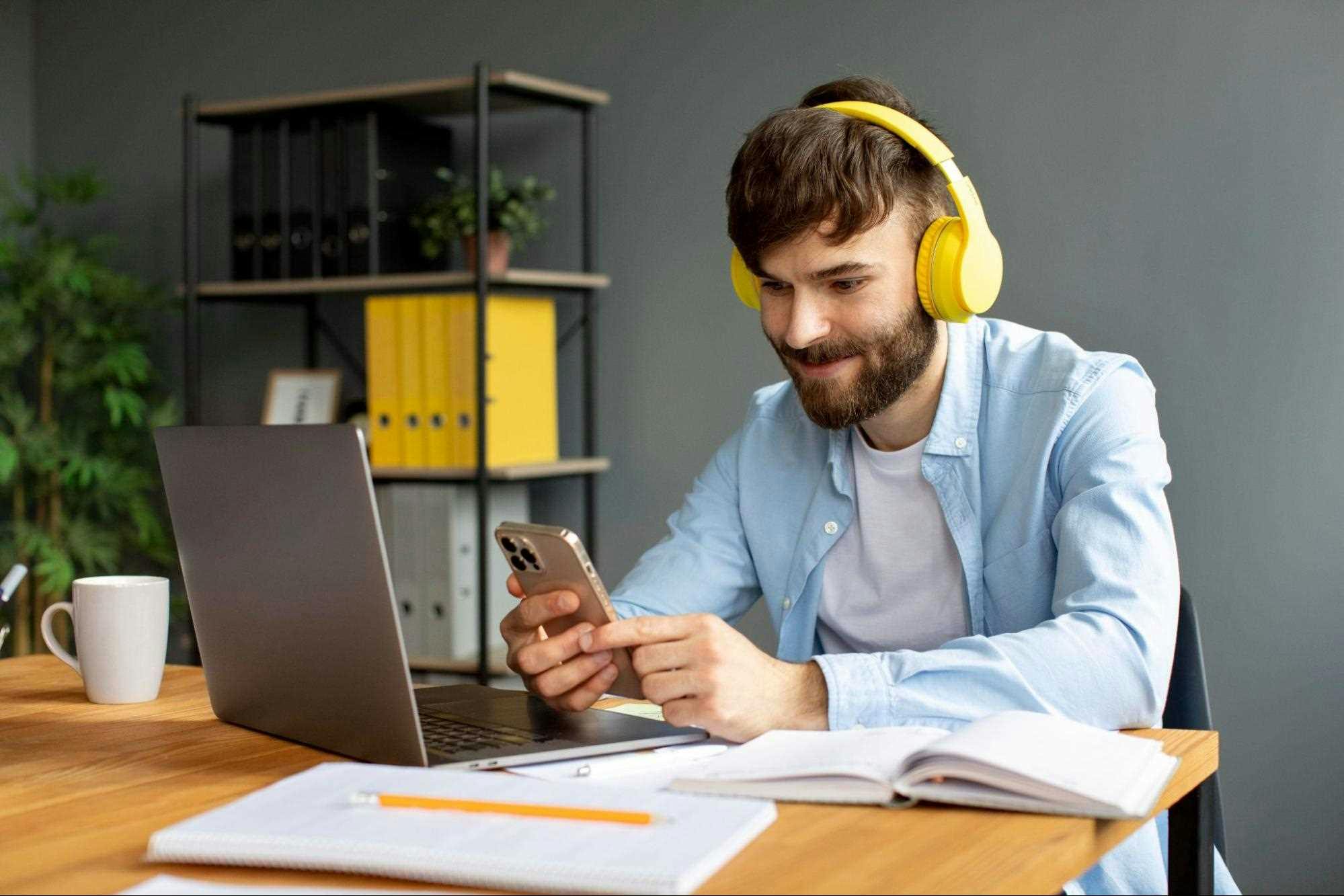 Homem usando o computador e o celular