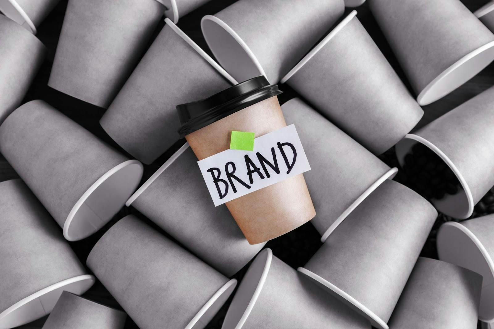 Copo de café com um papel escrito "brand"