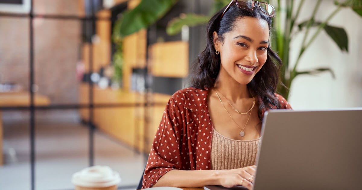 Mulher sorrindo, digitando no computador