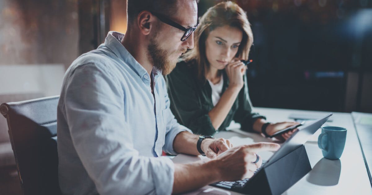 Homem e mulher analisando algo no computador