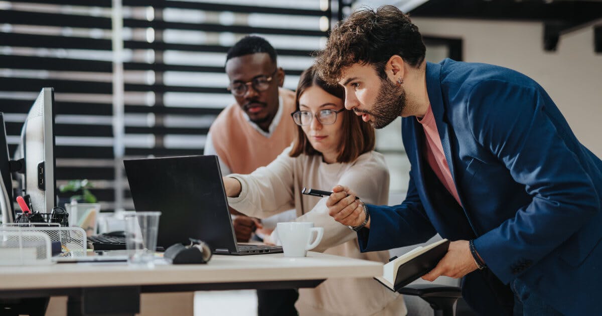 Três colegas de trabalho olhando o mesmo computador