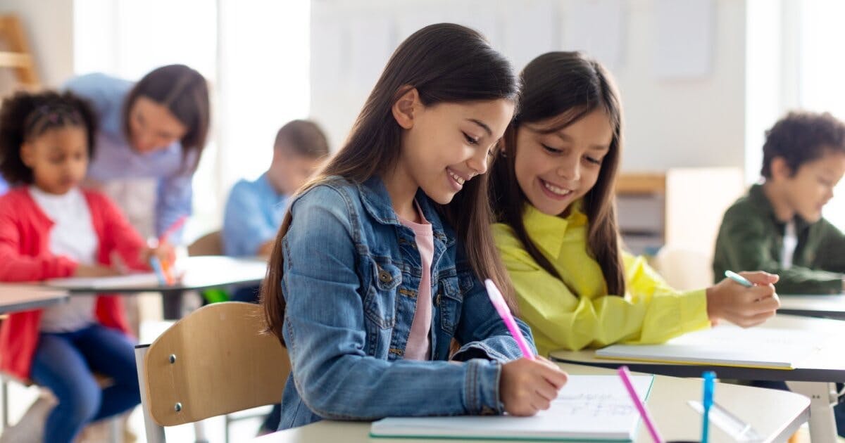 Duas crianças estudando em sala de aula