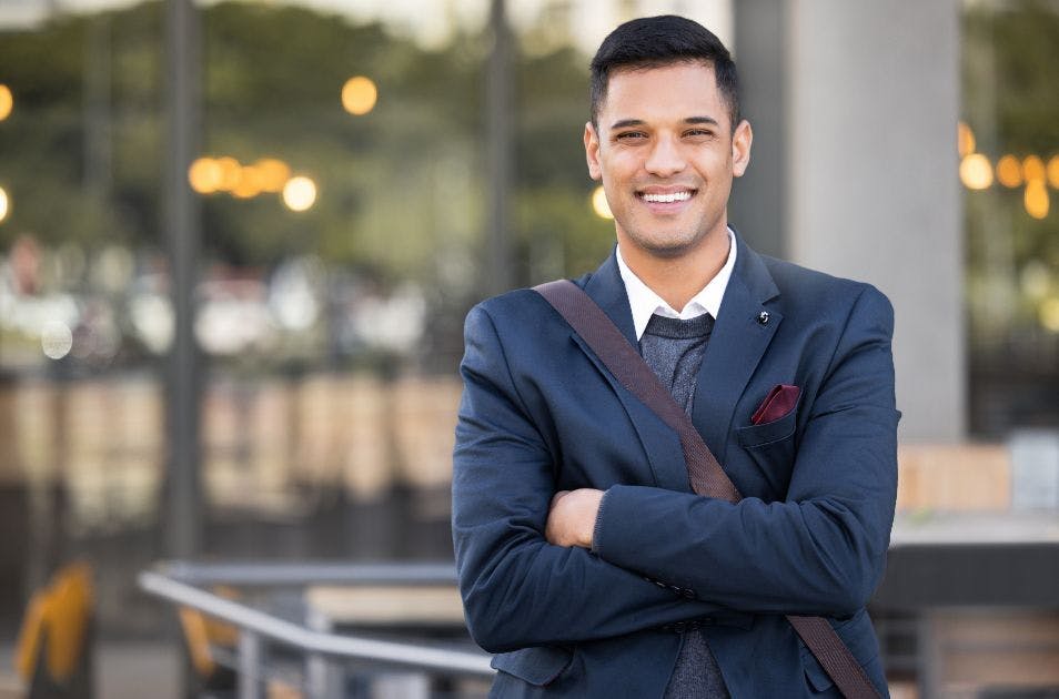 Homem vestindo um terno sorrindo para a foto.