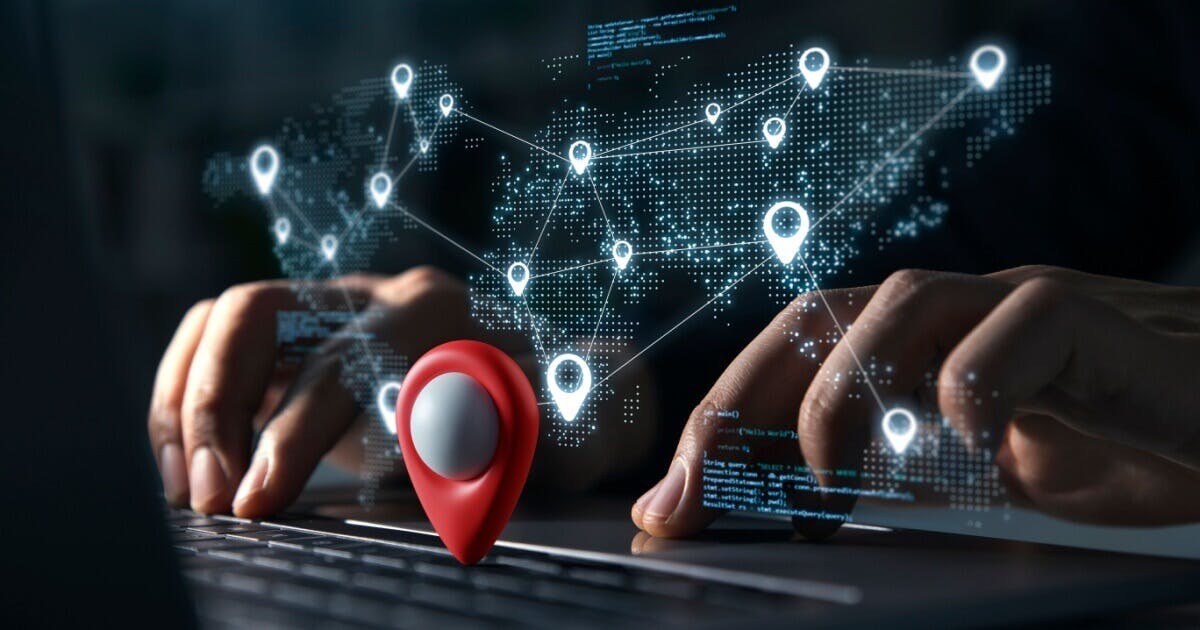 Pessoa digitando e um holograma de localização em cima do teclado.