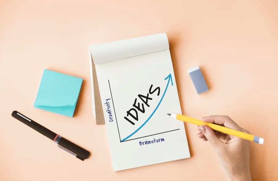 Pessoa anotando ideias para inovar e empreender, com papel, caneta e itens de escritório ao redor, simbolizando criatividade e inovação para negócios.