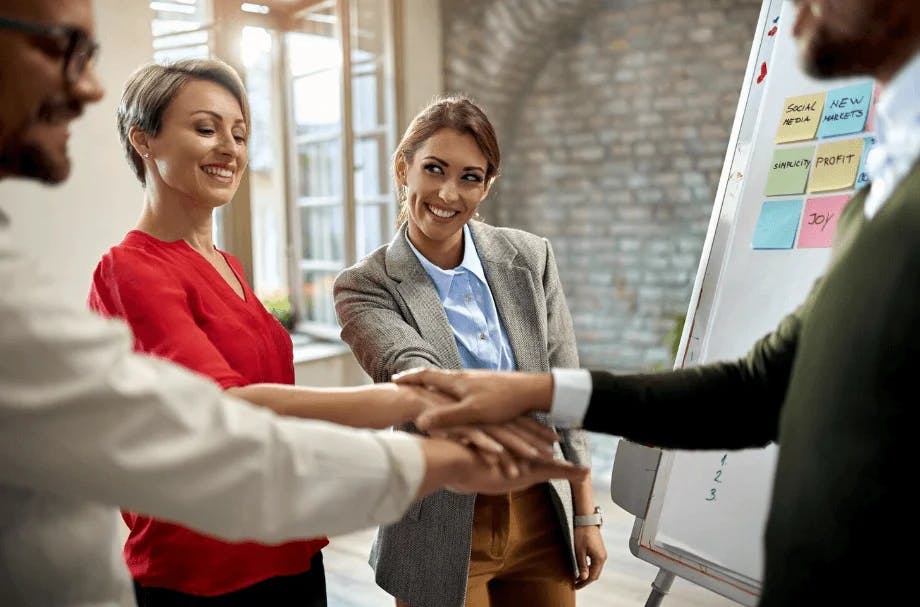 Equipe de profissionais de negócios celebrando um acordo com um aperto de mãos em ambiente corporativo, promovendo sucesso, colaboração e negócios.