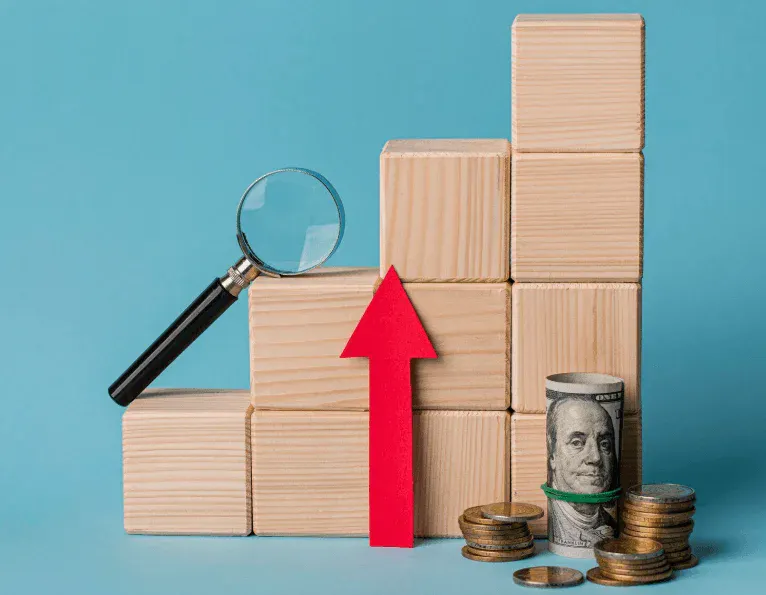 Imagem com blocos de madeira formando uma escada, uma lupa, uma seta vermelha apontando para cima, e moedas de dinheiro, representando crescimento financeiro e análise de investimentos.