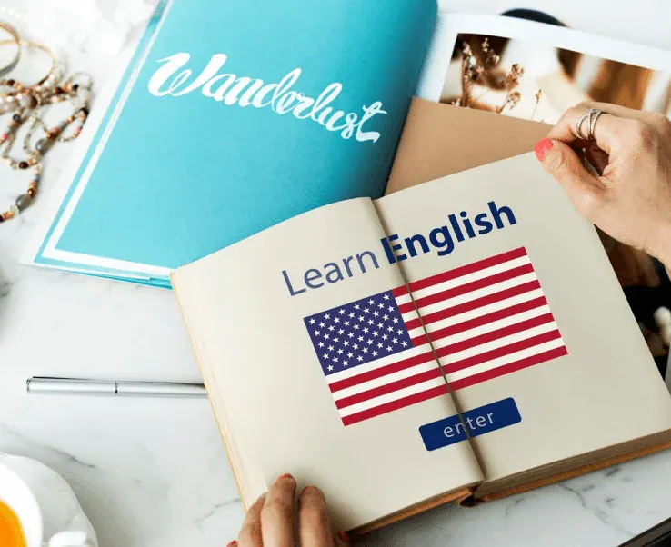  Imagem de um livro aberto com a frase Learn English e a bandeira dos Estados Unidos, incentivando o aprendizado do inglês.