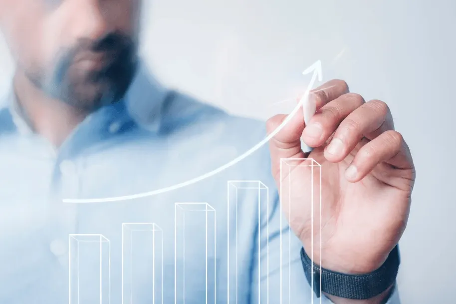 Homem desenhando com o dedo, no ar, uma sequência de gráficos de barras e uma seta apontando para cima, simbolizando crescimento e desenvolvimento. Visual corporativo de tecnologia e negócios.