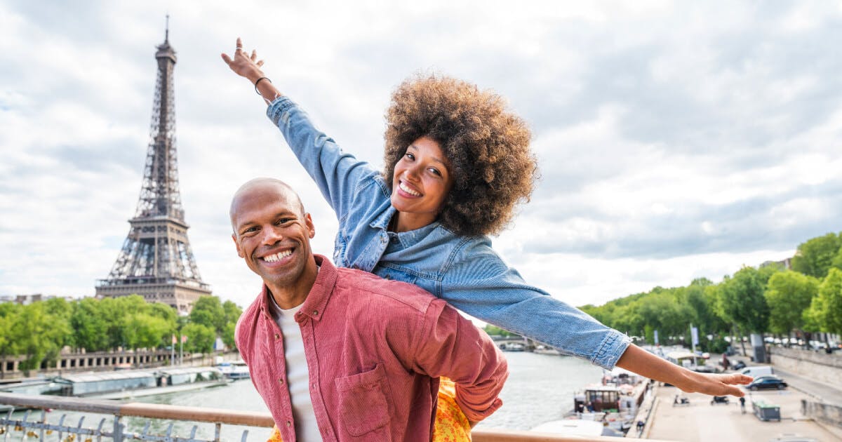 Casal feliz em Paris, França, desfrutando de um momento romântico sob a Torre Eiffel.