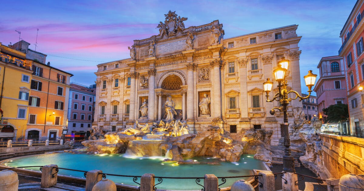 Fonte de Trevi em Roma, Itália, iluminada ao entardecer, com águas refletindo a luz suave do crepúsculo.