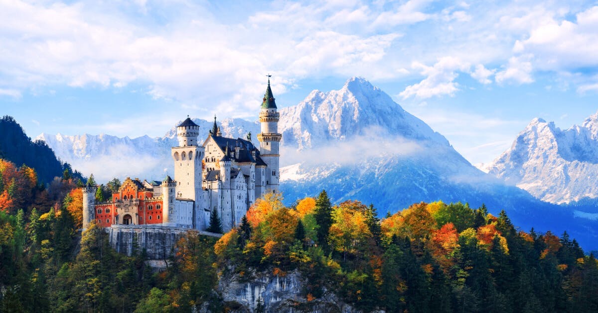 Castelo de Neuschwanstein na Alemanha, com torres majestosas e paisagens deslumbrantes ao redor.