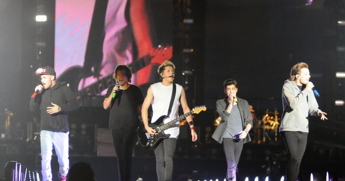 Banda One Direction em cima do palco durante um show.