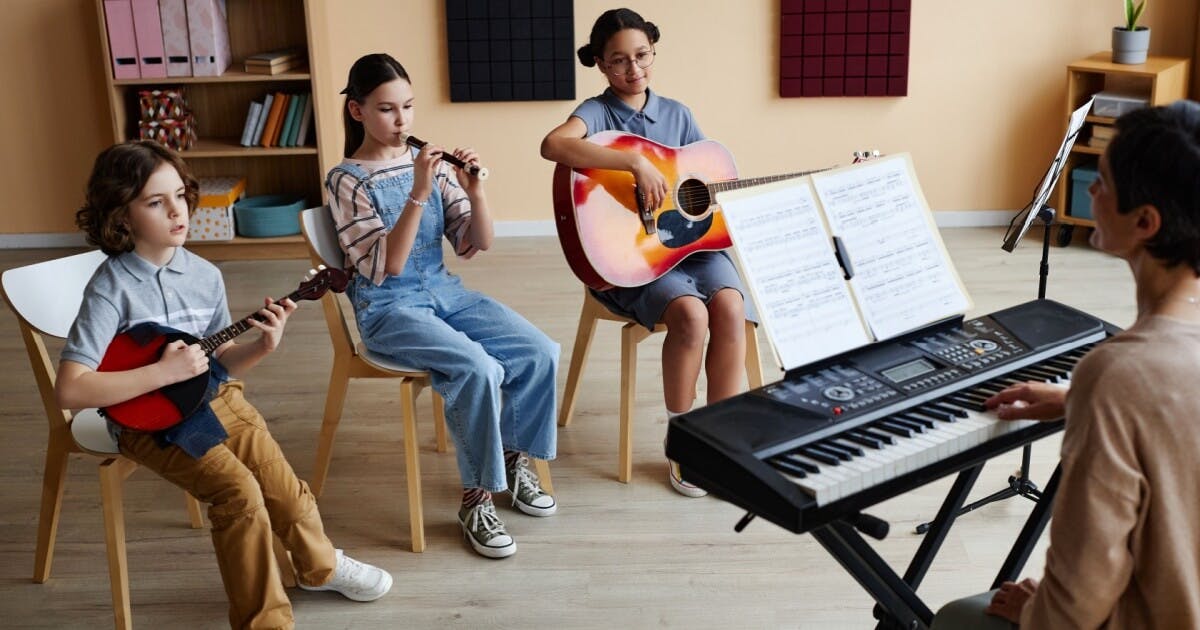 Uma professora de música e três crianças com um instrumento cada.