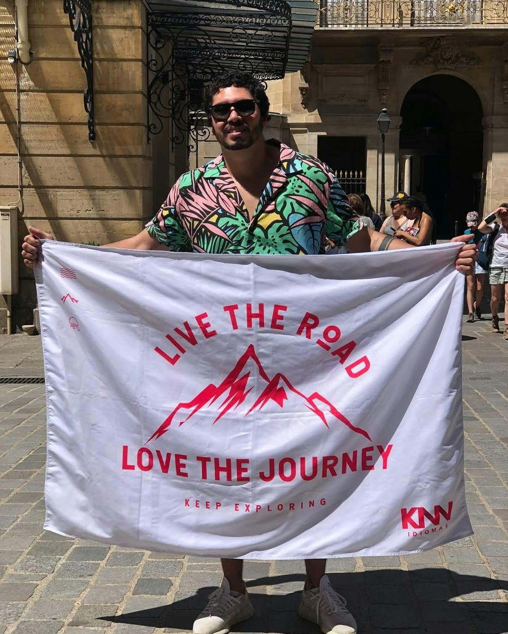 Franqueado André, da KNN Idiomas Nonoai, com a bandeira branca e vermelha da KNN Idiomas escrito "Live the road. Love the journey".