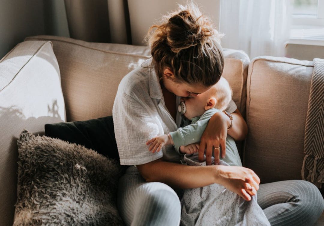 förälder kramar bebis soffa