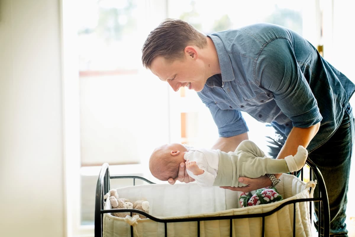 pappa lägger ner bebis i sängen