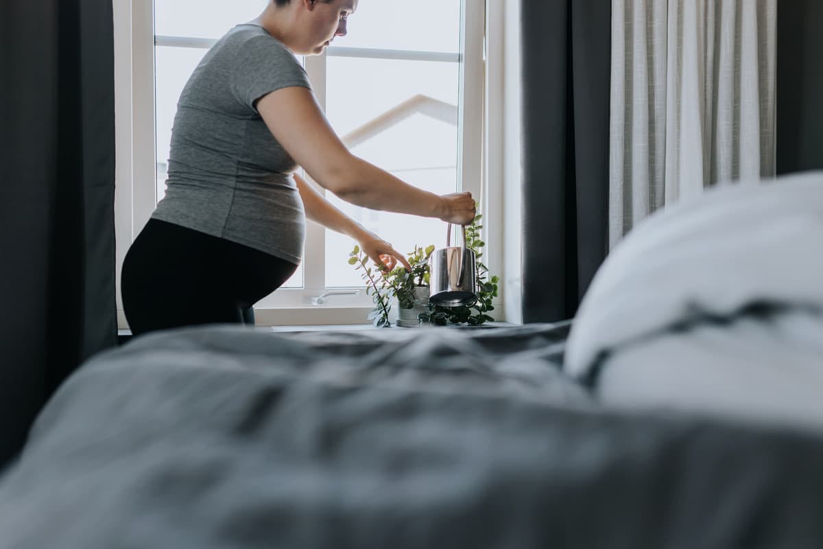gravid kvinna vattnar blommor