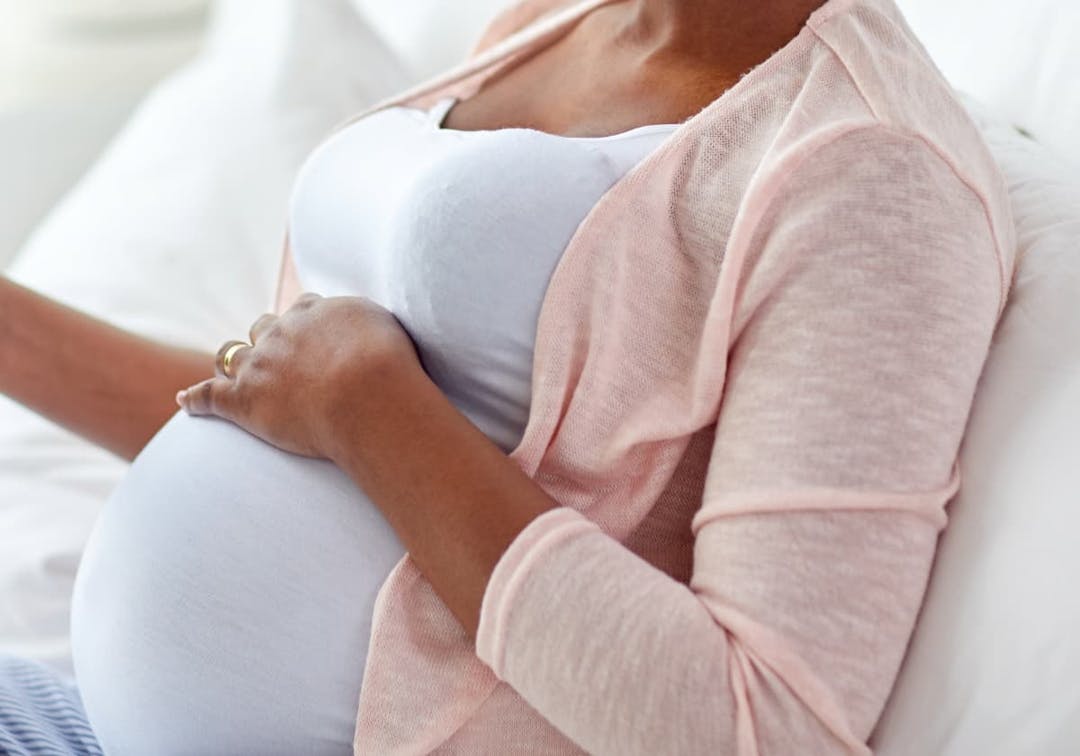 gravid kvinna som håller handen på magen