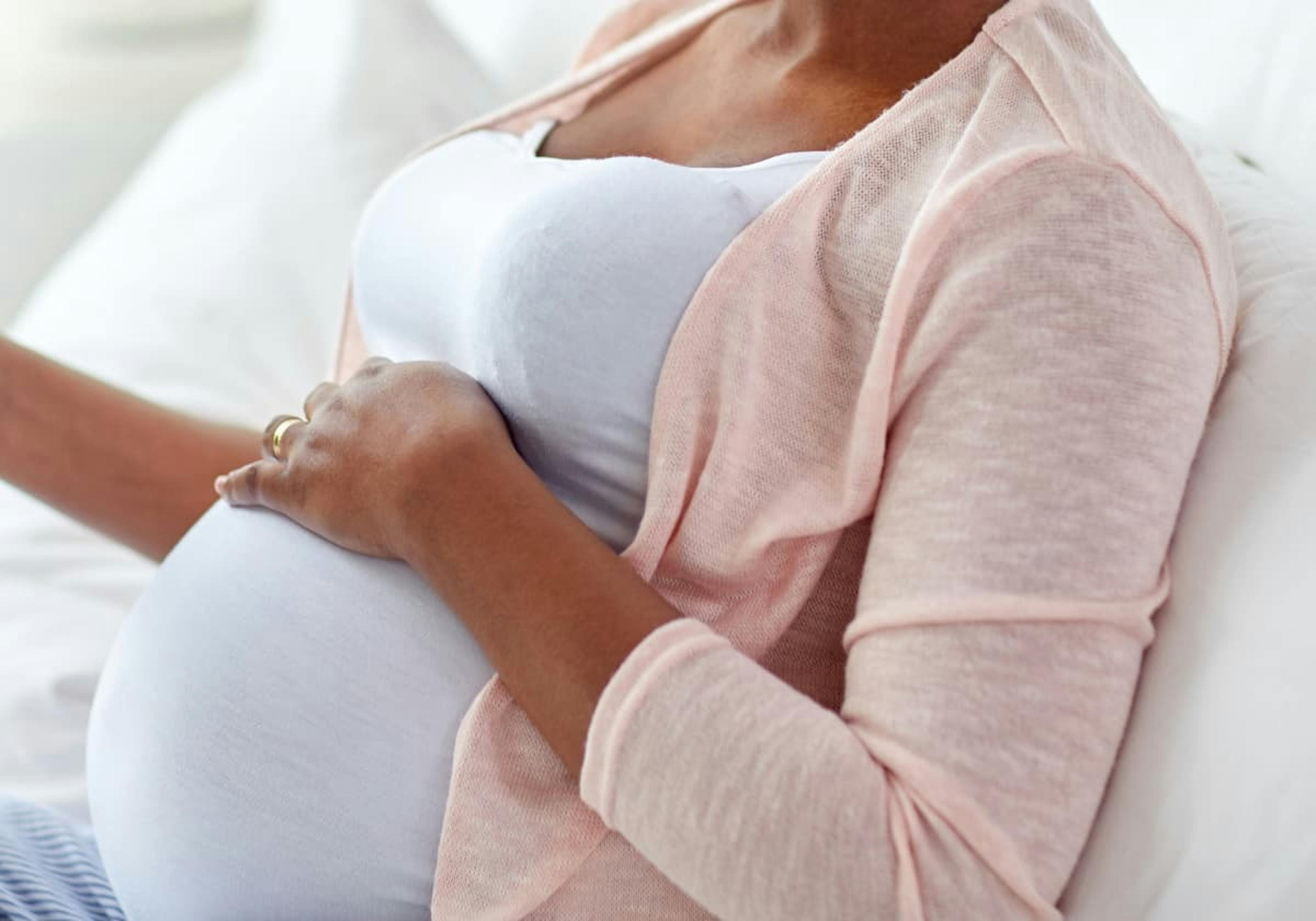 gravid kvinna som håller handen på magen