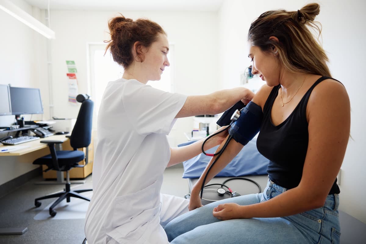 barnmorska tar blodtryck på tidigt gravid