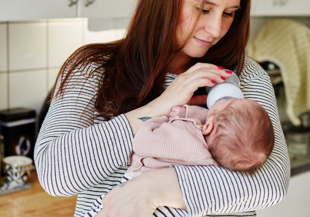 Mamma som flaskmatar sitt barn