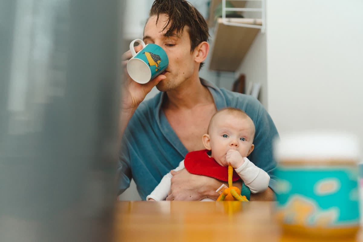 trött pappa med bebis i knät
