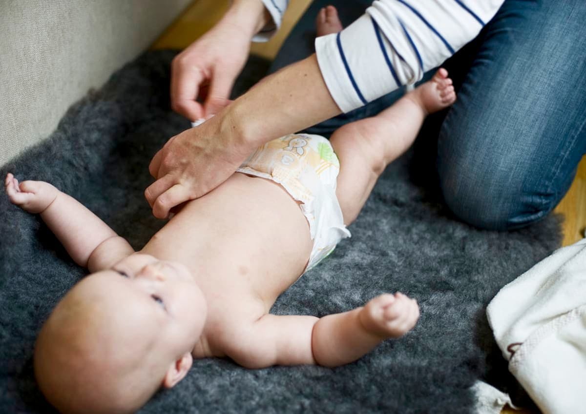 förälder byter blöja på bebis