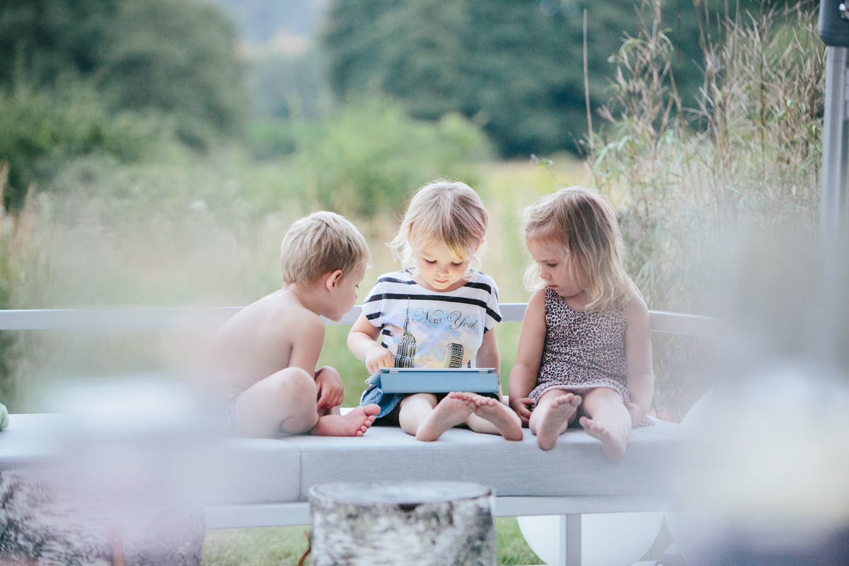 tre barn tittar på ipad